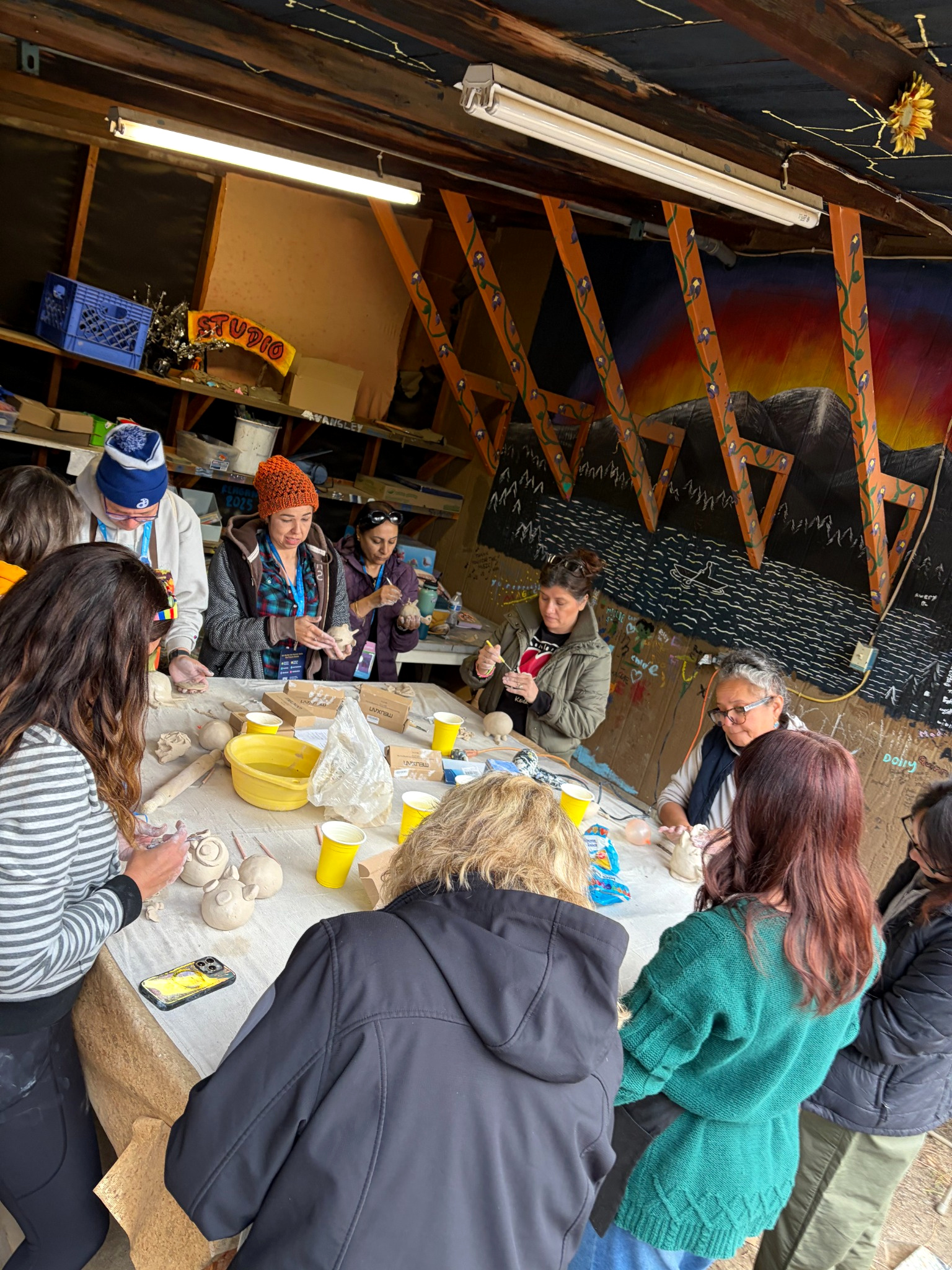 AAEA workshop participants working together around a studio table with clay
