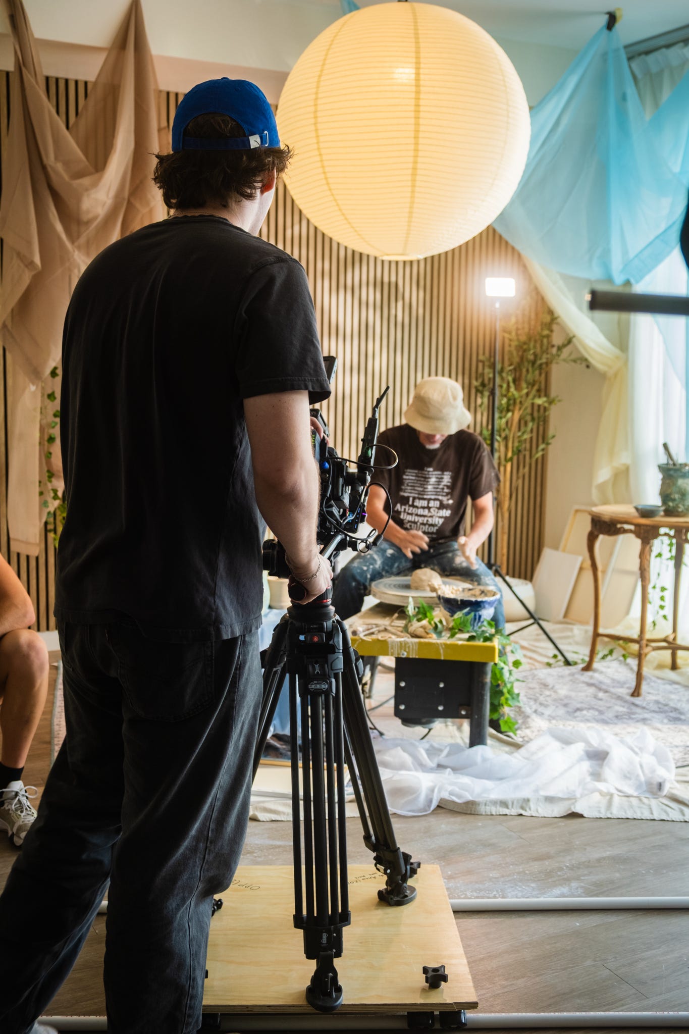 Camera operator filming Spencer Tracy Brown at the ceramics wheel on the Made Anew set