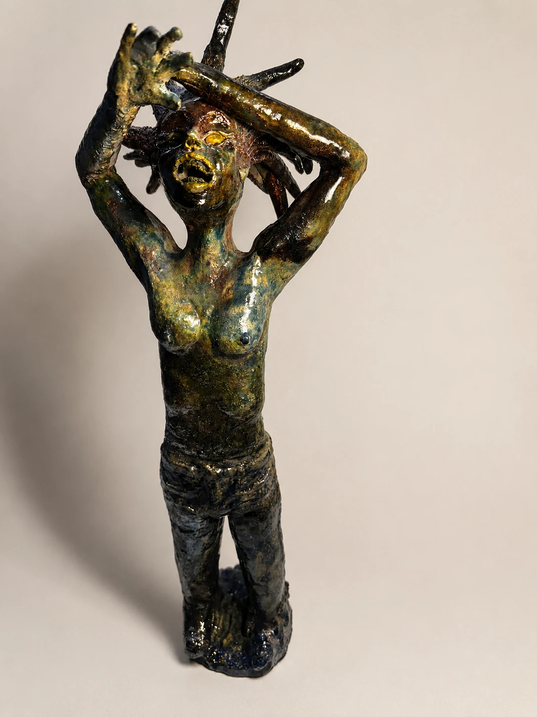 Expressive glazed figurative sculpture with both arms raised